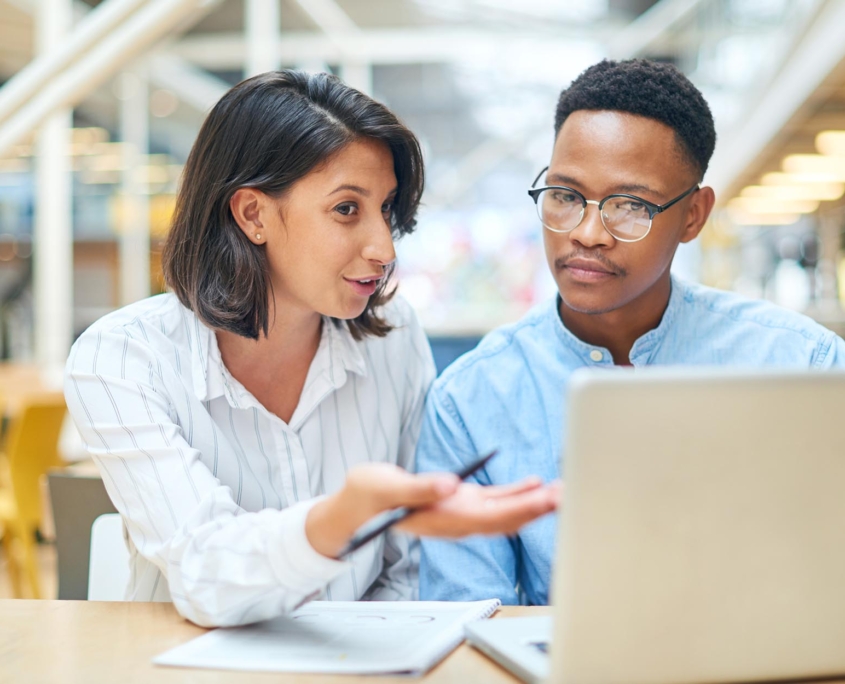 Two people talking at computer