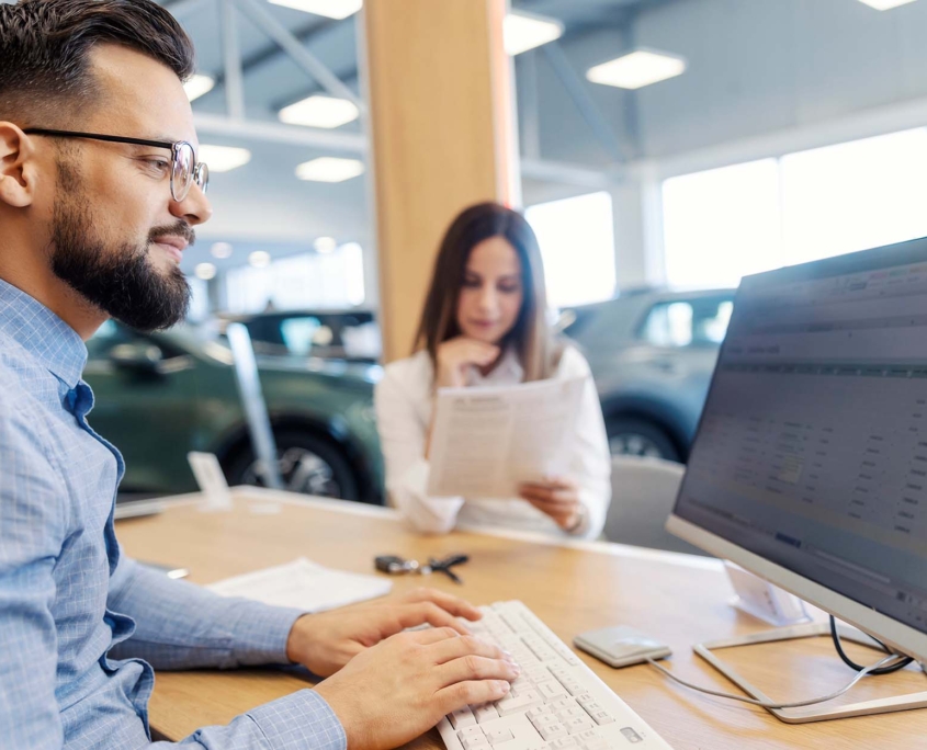 person at dealership working on computer