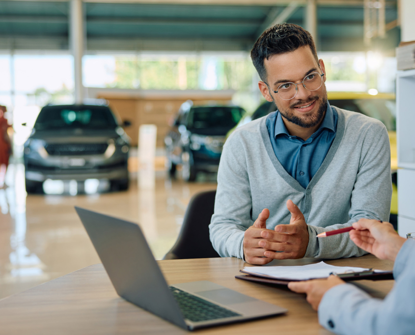 Worker at car dealership with laptop